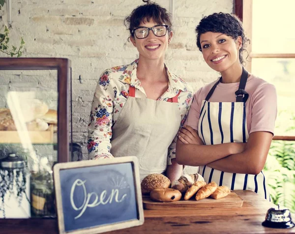 Donne amiche al negozio di panetteria sorridente — Foto Stock