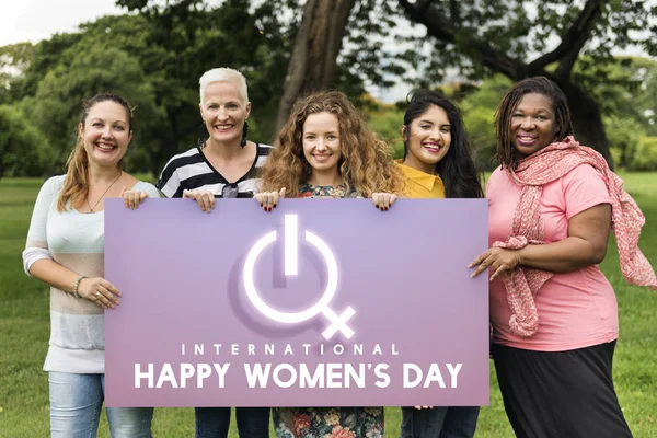 Cinco mujeres sonrientes sosteniendo pancarta — Foto de Stock