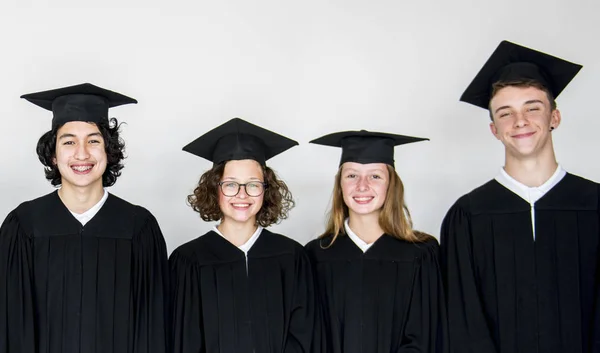 Students wearing graduation caps and gowns — Stock Photo, Image