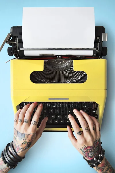 Tetovált személy írógéppel a gépelés. — Stock Fotó