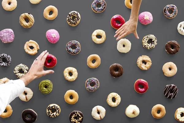 people hands above donuts