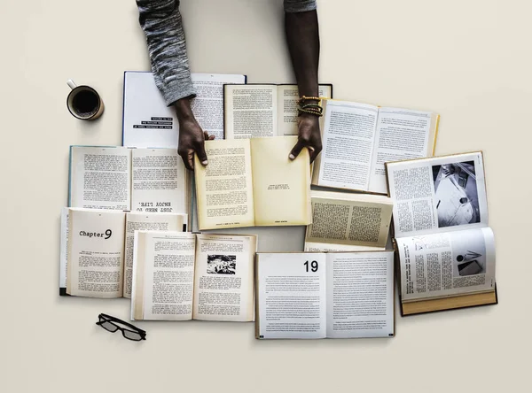 Mãos à mesa com muitos livros — Fotografia de Stock