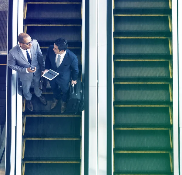 Businessmen using escalator — Stock Photo, Image