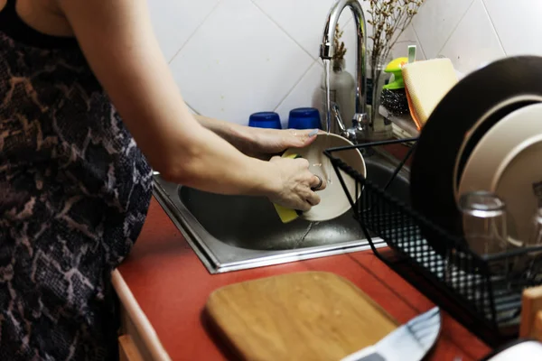 Женщина моет посуду дома — стоковое фото
