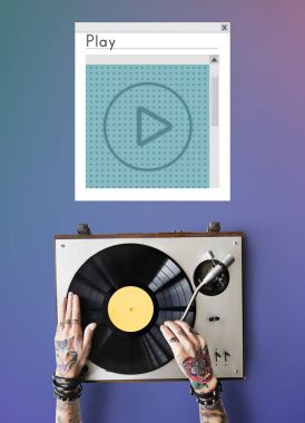 Vinil player ile dövmeli kişi.