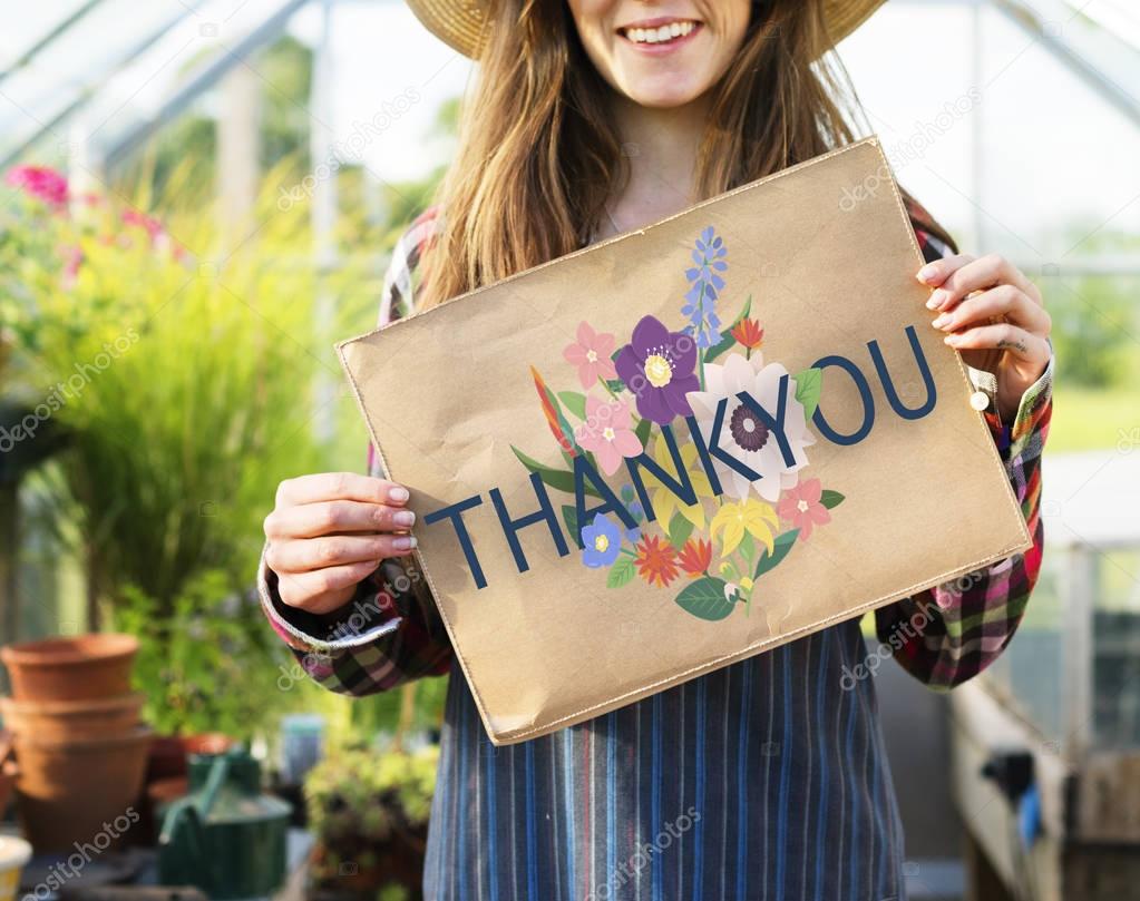 woman holding banner in greenhouse