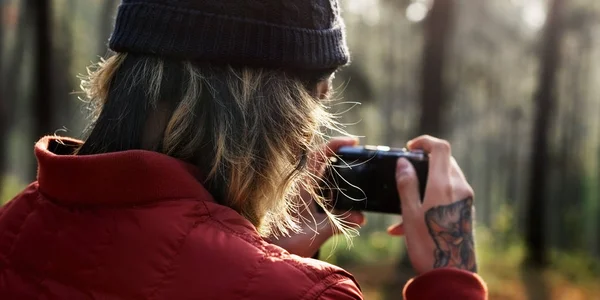 Man taking picture in front of forest — Stock Photo, Image