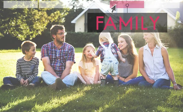 Velká rodina sedí na trávě — Stock fotografie