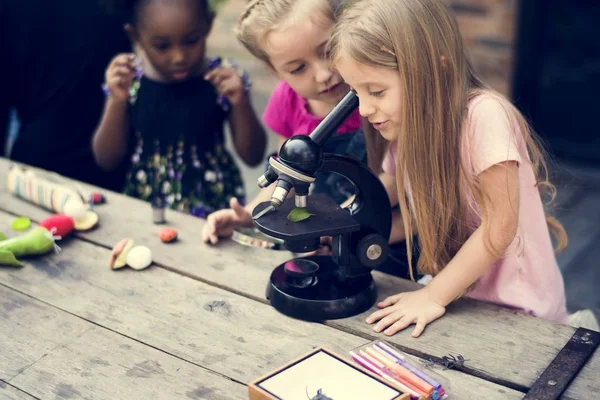 Діти вивчають науку з мікроскопом — стокове фото