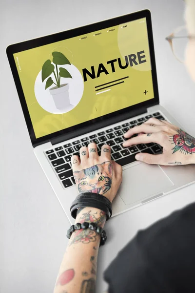 Tatuerade person att skriva på laptop. — Stockfoto