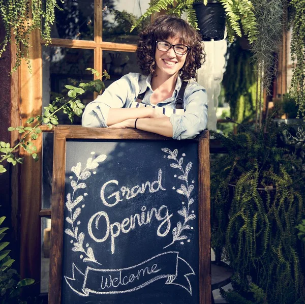 Eigenaar van retail winkel staande met bord — Stockfoto