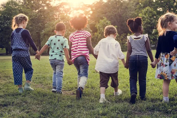 Barn leker i fältet grupp — Stockfoto