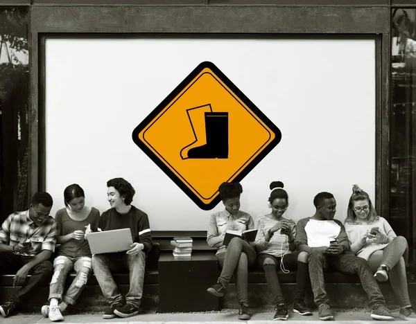 Jóvenes estudiantes sentados cerca de la pancarta —  Fotos de Stock