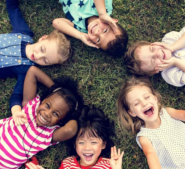 Enfants allongés sur l'herbe — Photo