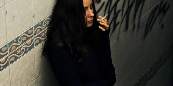 homeless suffering woman smoking cigarette