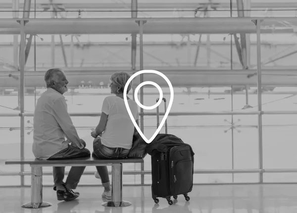Seniorenpaar sitzt auf Bank im Flughafen — Stockfoto