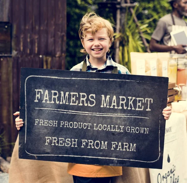 Boy holding board con mercato agricolo — Foto Stock