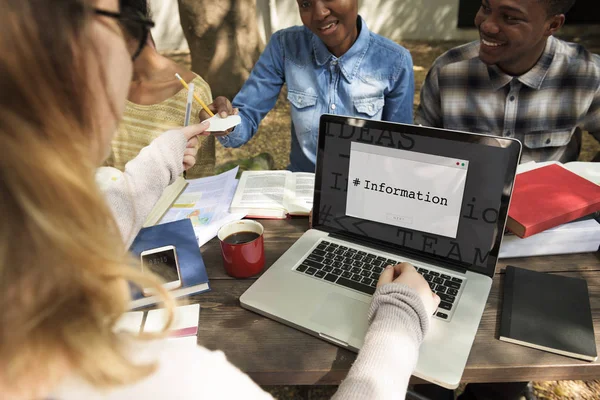 Studenti seduti a tavola con libri e laptop — Foto Stock