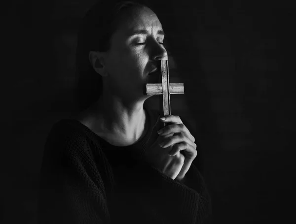Donna sofferente che tiene la croce e prega — Foto Stock