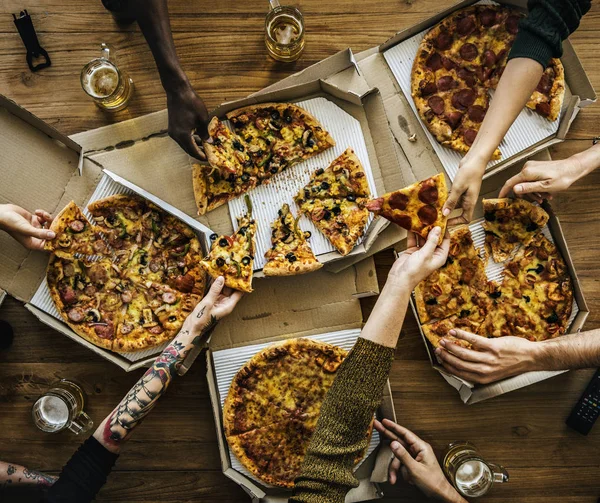 Menschen greifen nach Pizza — Stockfoto