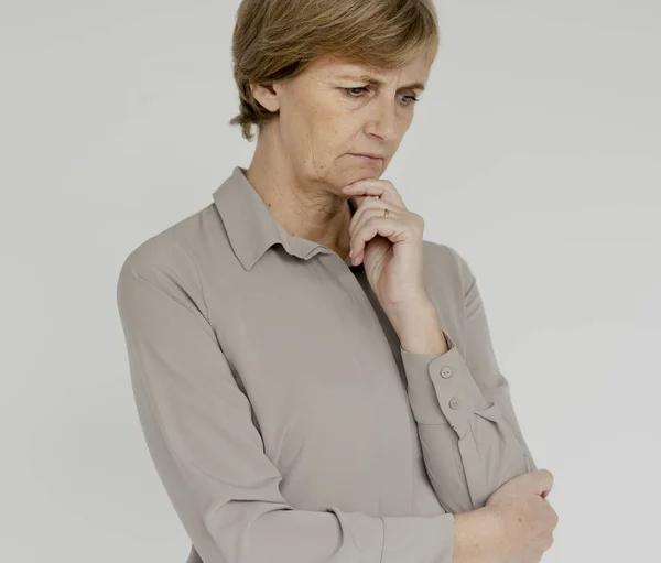 Pensive mature woman touching chin — Stock Photo, Image