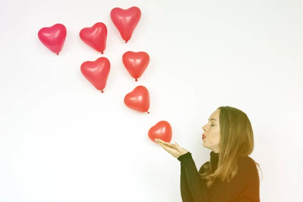 Femme soufflant ballons coeur — Photo