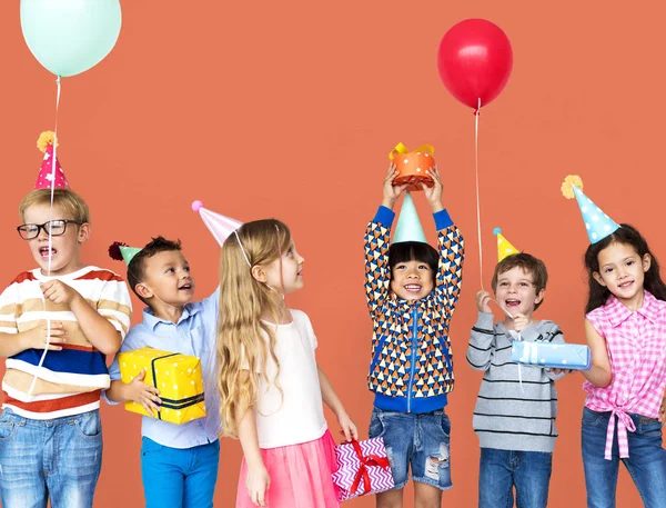 Niños en sombreros de fiesta con regalos —  Fotos de Stock
