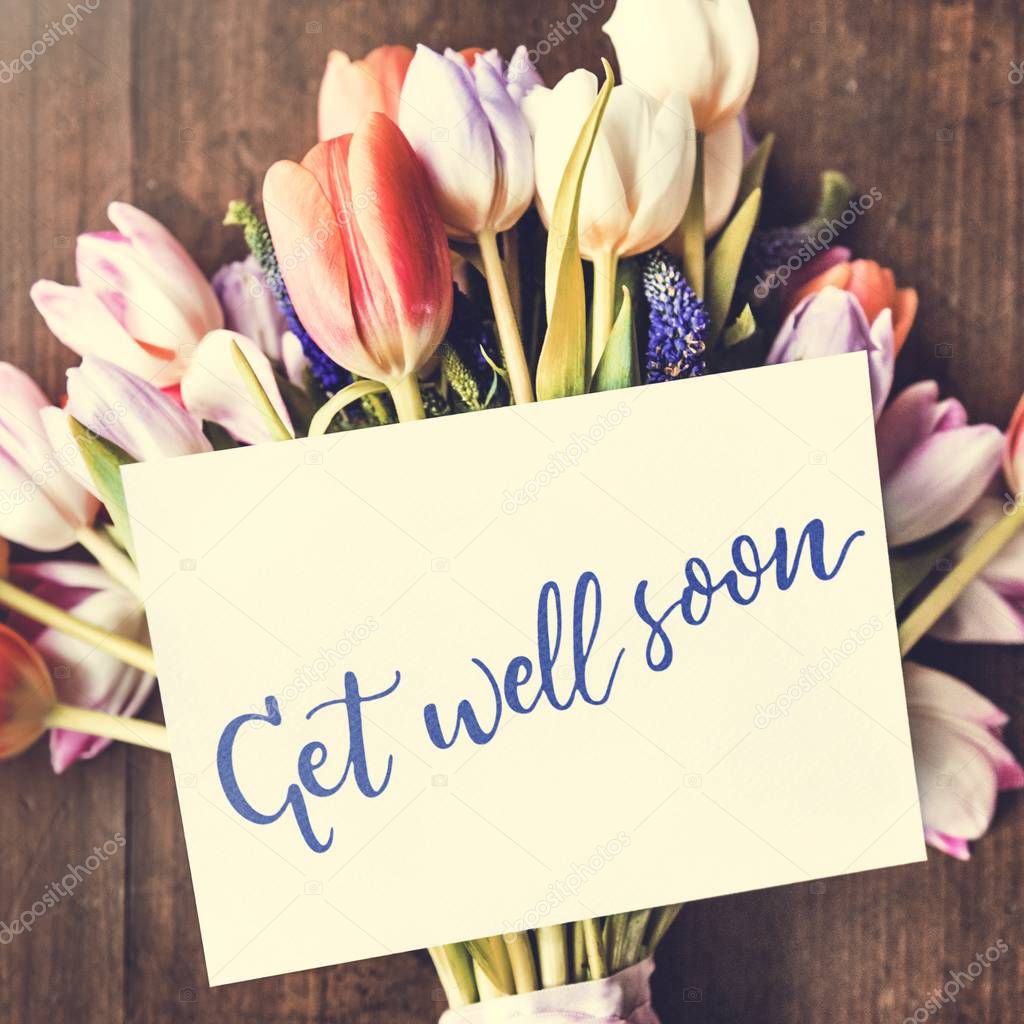 Beautiful bouquet with tulips and greeting card, text: get well soon