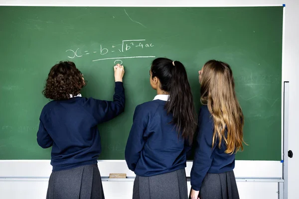 Estudiantes escribiendo en pizarra —  Fotos de Stock