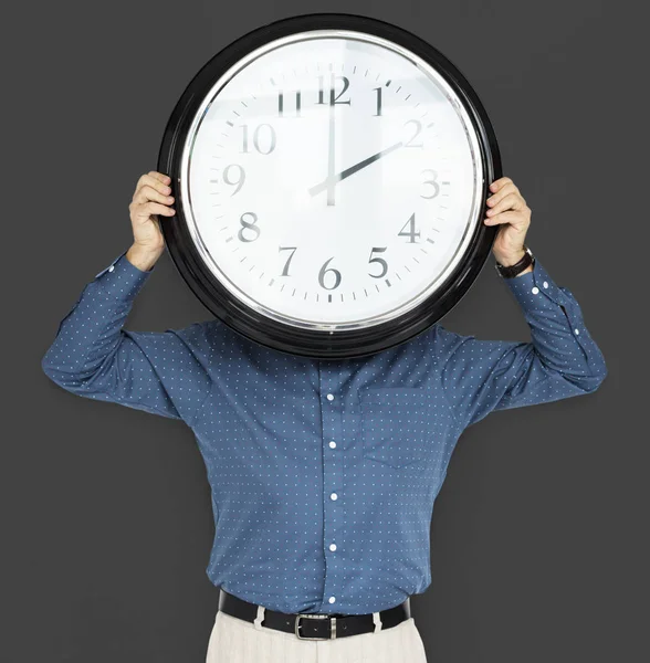 Hombre celebración reloj cubriendo la cara —  Fotos de Stock