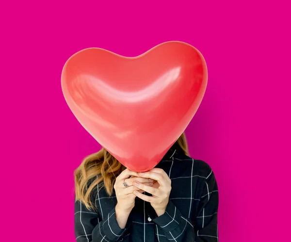 Kvinna som täcker ansiktet med hjärta ballong — Stockfoto