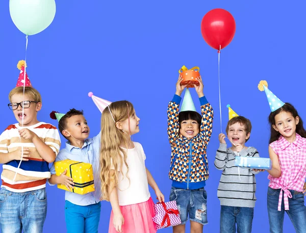 Niños en sombreros de fiesta con regalos — Foto de Stock
