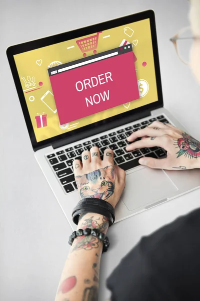 Getatoeëerde persoon typen op laptop. — Stockfoto