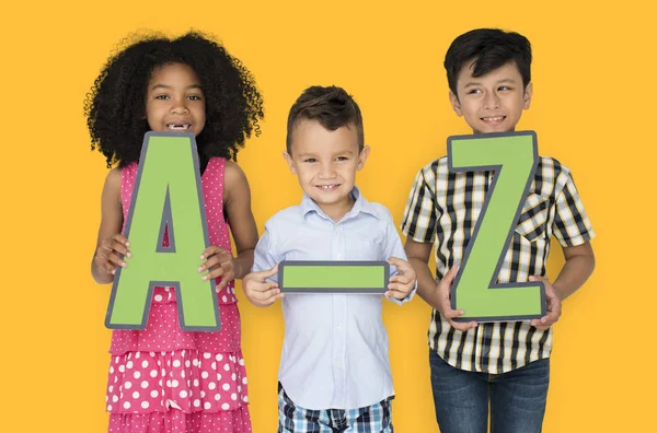 Niños sosteniendo cartas de papel A-Z —  Fotos de Stock
