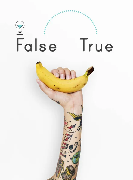 Tatuerade person hålla banan. — Stockfoto
