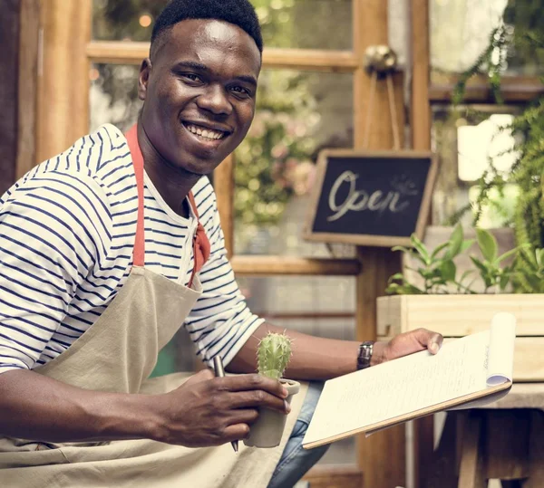 Afrikaanse man aan het werk in bloemen winkel — Stockfoto