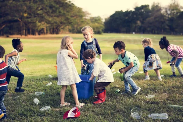 Barn separera papperskorgen för återvinning — Stockfoto