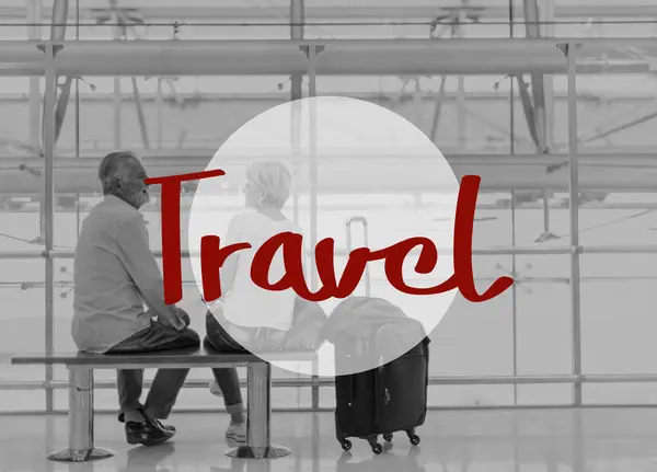 Пожилая пара, сидящая на скамейке в аэропорту — стоковое фото