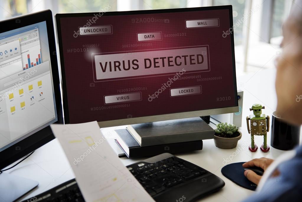 Businessman brainstorming at workplace table, documents concept, computer monitor with title: Virus Detected