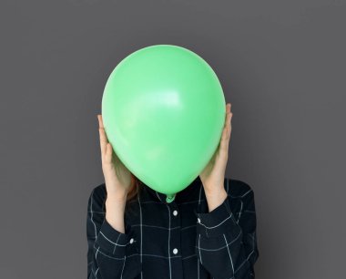 Yeşil balon ile yüz kapsayan kadın