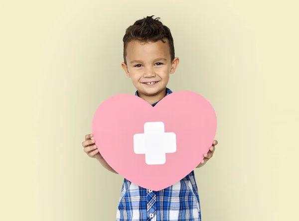 Jongen bedrijf hart met kruis — Stockfoto