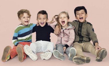 T katta oturan çocuk gülümseyen