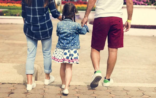Little girl walking with parents — Stock Photo, Image