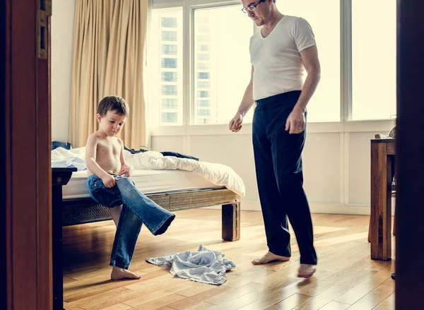 Батько допомагає синові одягатися — стокове фото