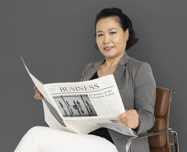 Азиатская деловая женщина с газетой — стоковое фото
