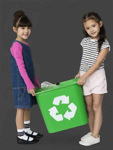 Dos niñas sosteniendo la papelera de reciclaje — Foto de Stock