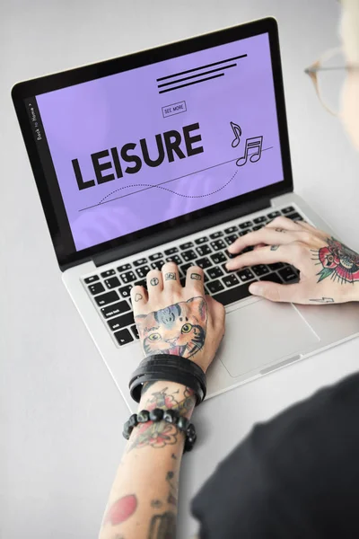 Getatoeëerde persoon typen op laptop. — Stockfoto