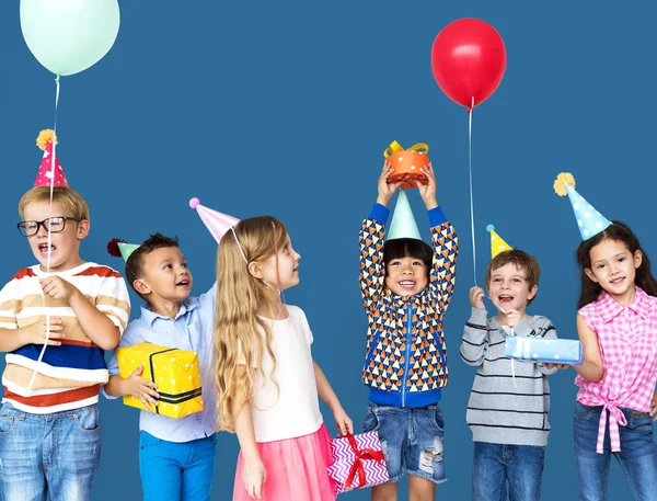 Barnen i partyhattar med gåvor — Stockfoto