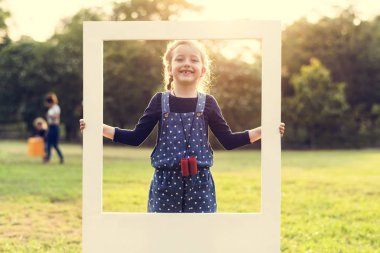bir çerçeve tutan kız