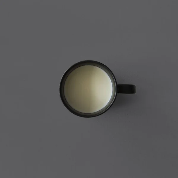 Schwarze Tasse mit Milch — Stockfoto
